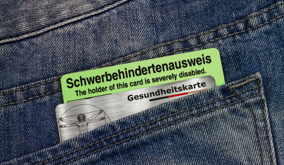 Schwerbehindertenausweis und Gesundheitskarte in einer Hosentasche