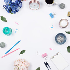 Feminine desk workspace frame with beauty arrangement of bouquet hydrangeas, laptop, clipboard, notebook, pencil and candle on white background. Flat lay, Top view office table desk with copy space. 