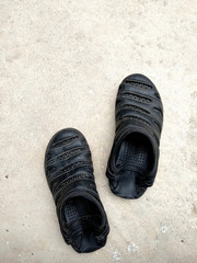  Black rubber sandals isolated on the white concrete background with shadow.Black rubber sandals isolated on the white concrete background with shadow.