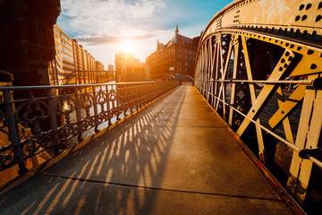 Brückenbogen mit Nieten in der Speicherstadt Hamburg während der goldenen Stunde des Sonnenuntergangs mit Abendlicht