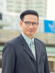 Asia young business man in front of the modern building in downtown .Concept of young  business people