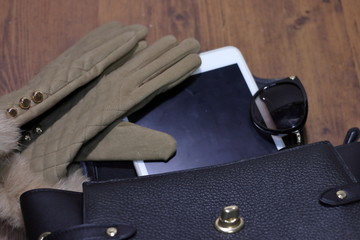女性用の小さなバッグとタブレットパソコンとサングラスとファー付きの手袋