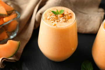 Glass of tasty melon smoothie on table