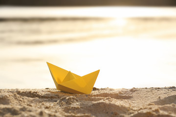 Fototapeta na wymiar Origami boat on sea shore