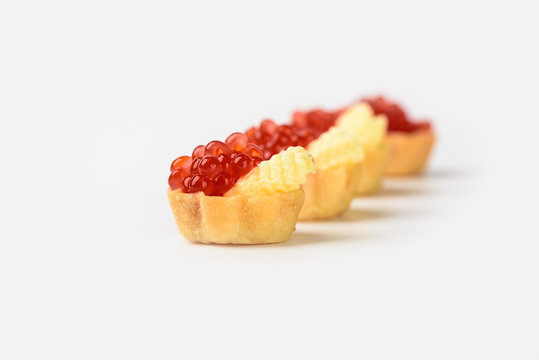 Red caviar in tartlets with butter isolated on white background