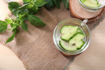 Glass cup of tasty cucumber water on table