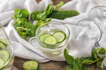 Glass cup of tasty cucumber water on white cloth