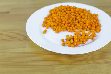 Sea buckthorn lies in a plate on a table