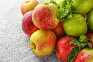 Ripe fresh apples with mint on light table