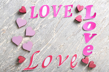 Words LOVE with color hearts on light background