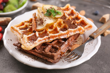 Delicious waffles with pear slices and honey on plate