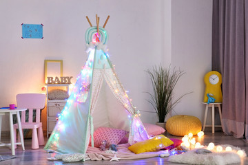 Cozy play tent for kids with glowing garland in room interior © Pixel-Shot