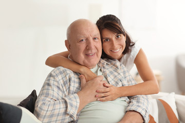 Happy elderly man with his daughter at home