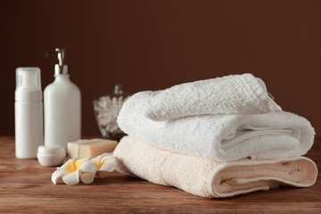 Plakat Stack of soft towels and cosmetics on wooden table