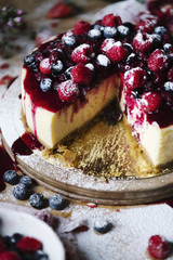Mixed berries cheesecake with a slice cut out
