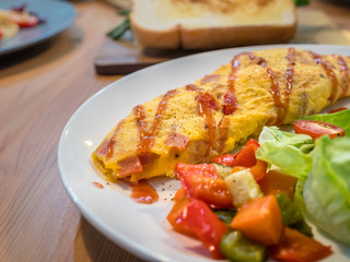 French Omelet with vegetable and salad, new menu design for healthy. Mix tomato, vegetable and seasoning when fried eggs. Fresh salad is compatible in same dish. A special meal for weight control.