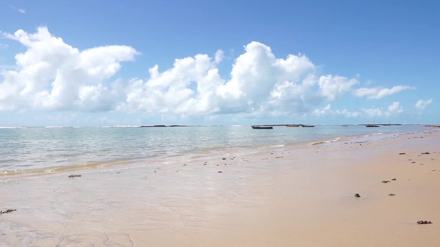 Tropical beach sunny day in Arraial D'Ajuda Bahia Brazil: Low Tide reflections pan RL