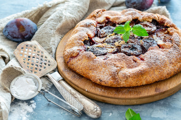 Homemade plum pie with a sprig of mint.