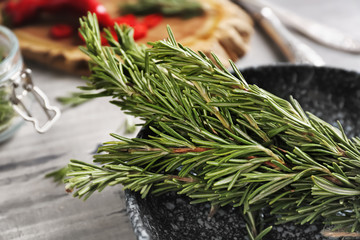 Plate with fresh rosemary on table, closeup