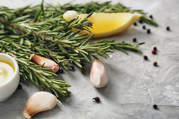 Fresh rosemary with spices, lemon and oil on light table