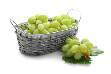 Basket with ripe juicy grapes on white background