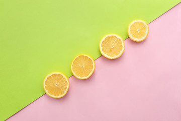 Slices of ripe lemon on color background