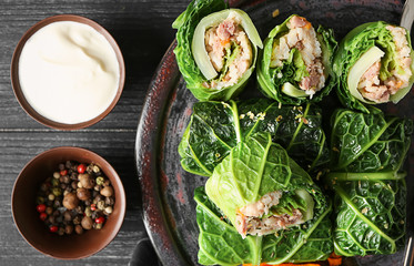 Plate with stuffed cabbage leaves on wooden table