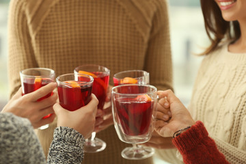 Friends drinking delicious mulled wine at party