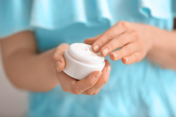 Woman applying body cream, closeup