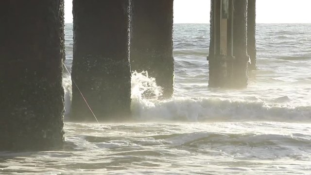 Dramatic waves crashing into a pier piling.