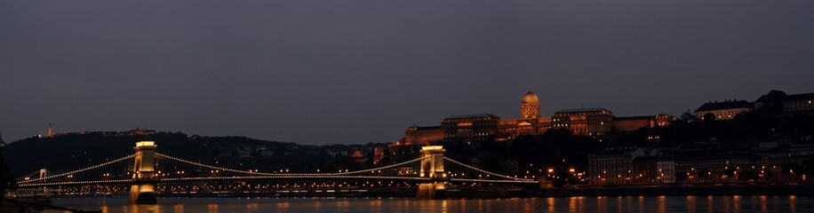 Fototapeta na wymiar Panorámica del puente de las cadenas y Bastión de los pescadores iluminados al atardecer en Budapest.