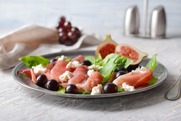 Plate with delicious fig salad on light table