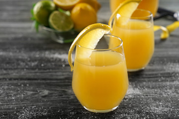 Glasses of fresh lemon juice on wooden table