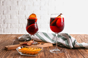 Glasses of delicious mulled wine on wooden table