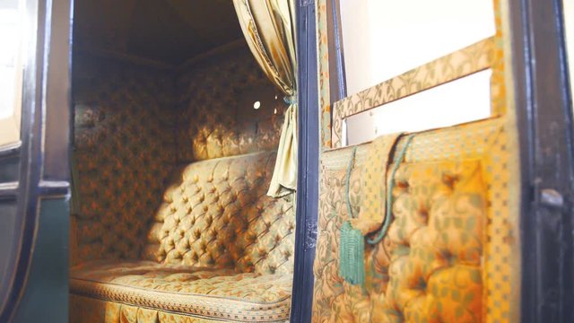 Rich women retro horse carriage inside details 4K. Dolly slide shot zoom-in of inside the vintage carriage in focus. Beautiful design of the seat.