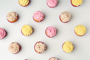 Delicious cupcakes on white background, flat lay