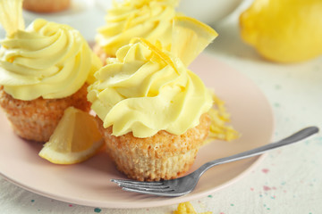 Plate with delicious lemon cupcakes on table, closeup
