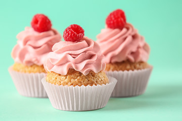 Delicious cupcakes on color background