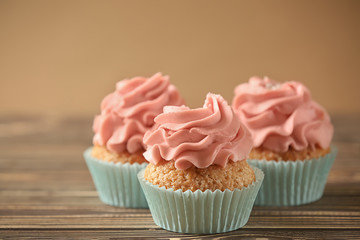 Delicious cupcakes on wooden table