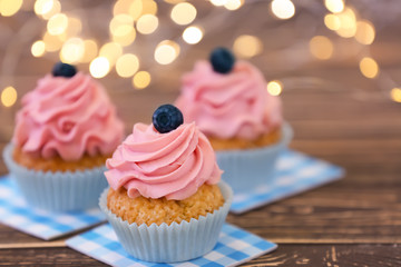 Delicious cupcakes on wooden table
