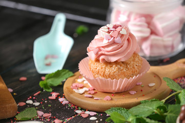 Delicious cupcake on wooden board