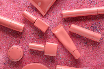 Set of pink decorative cosmetics on shiny pink glitter