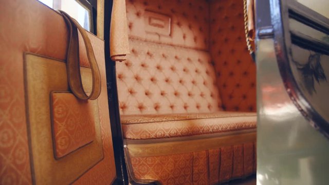 Dolly slide zoom-in to a vintage carriage inside 4K. Camera slide towards the inside the vintage carriage in focus with a stylish seat.