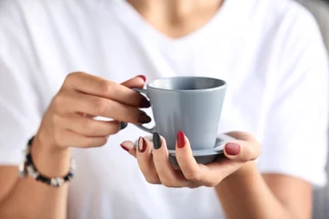 Gordijnen Woman with stylish beautiful manicure drinking coffee, closeup © Pixel-Shot