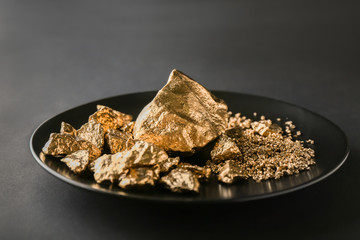 Gold nuggets on black plate
