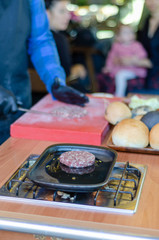 Chef is preparing a burger on the table..