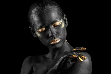 Foto auf Acrylglas Schwarz Gold Beautiful woman with black and golden paint on her body against dark background  © Pixel-Shot