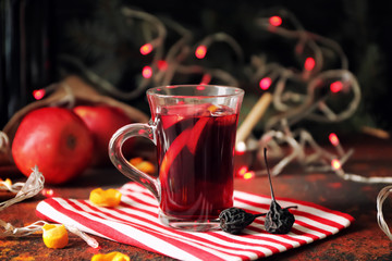 Glass cup of delicious mulled wine on color table
