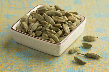 Bowl with green cardamom pods