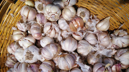 White garlic pile texture. Fresh garlic on market table closeup photo. Vitamin healthy food spice image. Spicy cooking ingredient picture. Pile of white garlic heads. White garlic head heap top view